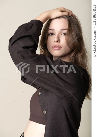 Young woman posing in studio with hand on head 135960812