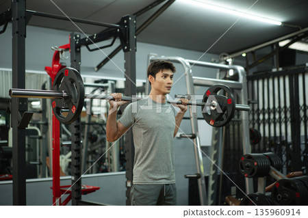 A man doing a squat and lifting weights A man doing a squat and lifting weights 135960914