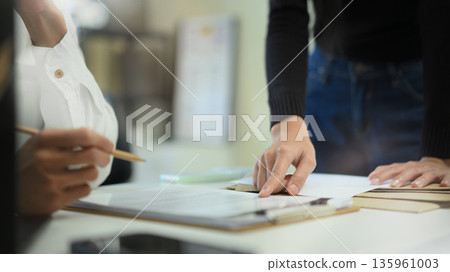 Two business people planing, consulting and meeting with paper work at office Two business people planing, consulting and meeting with paper work at office 135961003
