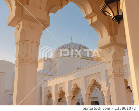 Elegant exterior showcases traditional Arabic design elements with ornate arches and decorative lanterns. White marble walls and geometric patterns create authentic oriental atmosphere Elegant exterior showcases traditional Arabic design elements with ornate arches and decorative lanterns. White marble walls and geometric patterns create authentic oriental atmosphere 135961078