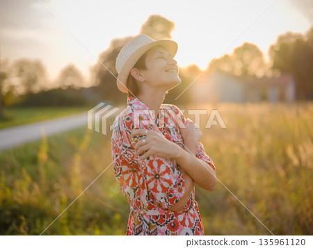 young woman embracing herself, self-love in action, mental health advocate, practicing self-care for finding inner peace, in European countryside 135961120