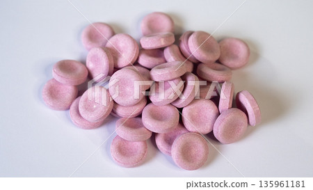 Pink Candies On White Background, Confectionery Arrangement Against Neutral Backdrop, Bright Pink Candy Pieces Displayed On White Studio Surface Suitable For Advertising Imagery 135961181