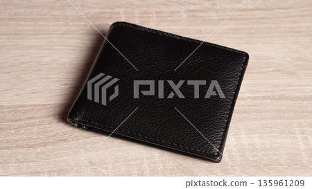 Black Leather Wallet On Wooden Surface, Minimalist StillLife Showcasing Sleek Stitching, Compact Fold Design, Warm Wood Grain, Soft Studio Lighting, Modern Everydaycarry Aesthetic 135961209