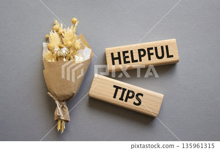 Helpful tips symbol. Wooden blocks with words Helpful tips. Beautiful grey background with bouquet of flowers. Business and Helpful tips concept. Copy space. Helpful tips symbol. Wooden blocks with words Helpful tips. Beautiful grey background with bouquet of flowers. Business and Helpful tips concept. Copy space. 135961315