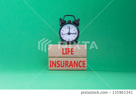 Life insurance symbol. Concept word Life insurance on wooden blocks. Beautiful green background with alarm clock. Business and Life insurance concept. Copy space 135961341