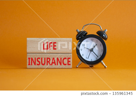 Life insurance symbol. Concept word Life insurance on wooden blocks. Beautiful orange background with alarm clock. Business and Life insurance concept. Copy space 135961345