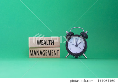 Wealth Management symbol. Concept words Wealth Management on wooden blocks. Beautiful green background with alarm clock. Business and Wealth Management concept. Copy space 135961360