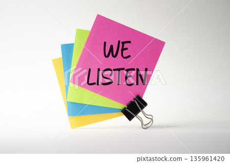 We listen symbol. Pink sticky note with words We listen. Beautiful white background. Business and We listen concept. Copy space. We listen symbol. Pink sticky note with words We listen. Beautiful white background. Business and We listen concept. Copy space. 135961420