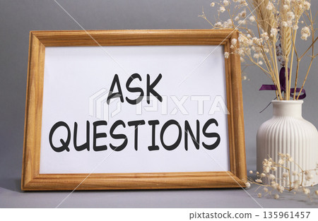 Ask Questions symbol. Concept words Ask Questions on beautiful wooden picture frame. Beautiful grey background with flower vase. Business and Ask Questions concept. Copy space. 135961457