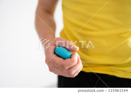 Man Squeezing Hand Grip Strengthener 135961544