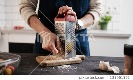 Girl Chef Grating Hard Parmesan Cheese 135961591