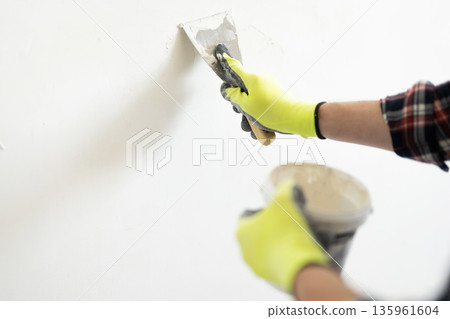 Worker Applying Wall Putty With Spatula Worker Applying Wall Putty With Spatula 135961604