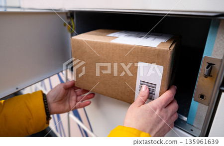 Girl Picking Up A Parcel From Parcel Automated Locker Girl Picking Up A Parcel From Parcel Automated Locker 135961639