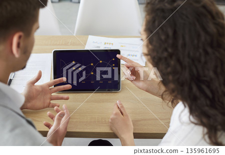 Business discussion of colleagues using tablet for data analysis, chart presentation Business discussion of colleagues using tablet for data analysis, chart presentation 135961695