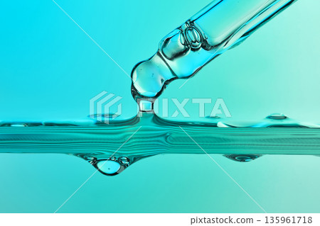 Pipette dropping liquid into blue chemical solution Pipette dropping liquid into blue chemical solution 135961718
