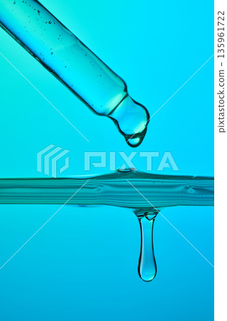 Hydrating serum droplet falling into blue liquid Hydrating serum droplet falling into blue liquid 135961722