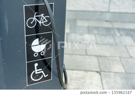 Pictograms on the sidewalk depicting a bicycle, a stroller, and a wheelchair 135962187
