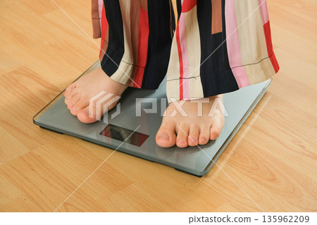 Bare Feet Standing on Modern Digital Bathroom Scales for Weighing. Bare Feet Standing on Modern Digital Bathroom Scales for Weighing. 135962209