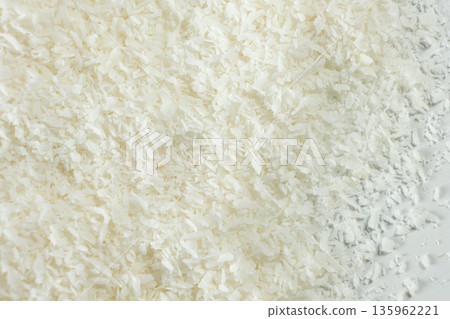 Pile of coconut flakes on white background macro 135962221