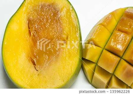 Close-up of overripe mango fruit with soft texture and dark spots. 135962226