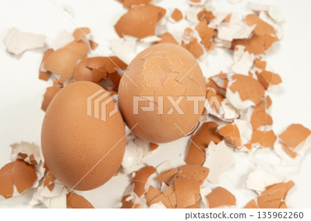 Two brown boiled eggs with cracked shell on white background. 135962260