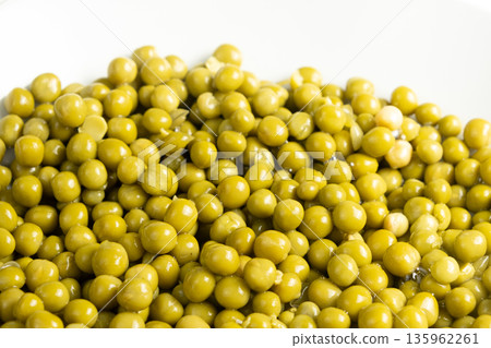 Macro view of many round green peas, canned product 135962261