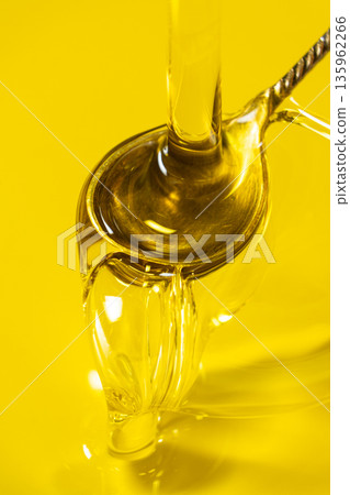 Pouring extra virgin olive oil into silver spoon Pouring extra virgin olive oil into silver spoon 135962266