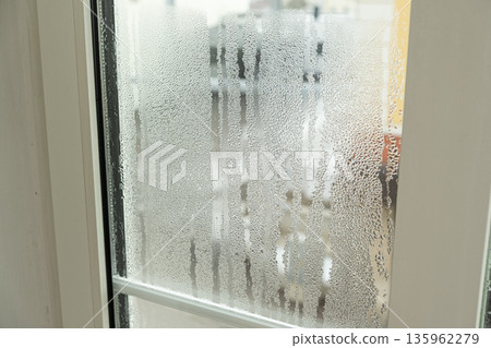 Close up of misted window glass with water streaks and droplets Close up of misted window glass with water streaks and droplets 135962279