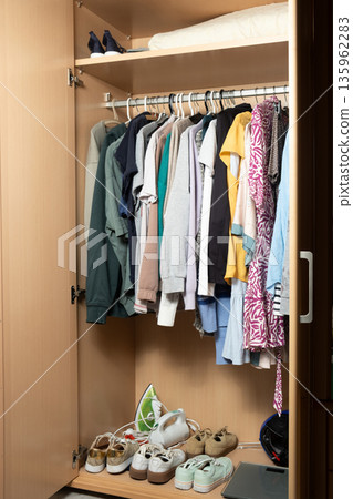 Realistic messy wardrobe interior with different garments and sneakers 135962283
