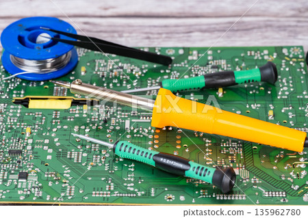 electrical board with a soldering iron and screwdrivers 135962780