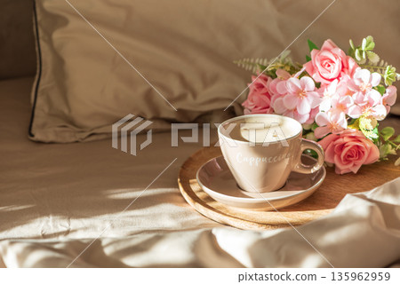 Cappuccino Cup and Flowers on Tray with Satin Bedding in Sunlight. Valentine's or Mother's Day Celebration Cappuccino Cup and Flowers on Tray with Satin Bedding in Sunlight. Valentine's or Mother's Day Celebration 135962959