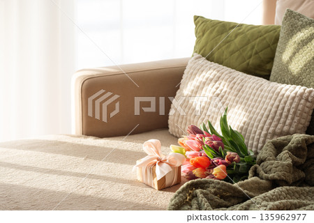 Tulip Bouquet and Gift Box on Cozy Sofa. Warm Spring Stylelife with Sunlight 135962977