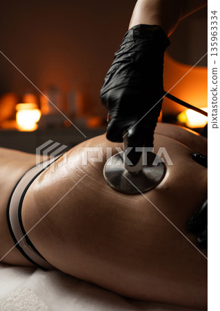 Cosmetologist performing RF lifting body therapy focused on noninvasive skin tightening and aesthetic improvement. 135963334