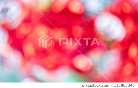 Vibrant display of red and yellow bokeh lights creates abstract, festive blurred background. Soft white blurs add contrast and depth to this colorful scene. Shimmering Christmas or New Year backdrop. 135963346