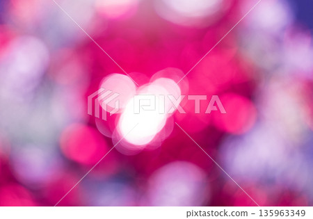 Defocused photography features bokeh effect dominated by pink and magenta colors. Blurred circles of light overlap, with cluster of bright white circles centered in the frame. Abstract background. Defocused photography features bokeh effect dominated by pink and magenta colors. Blurred circles of light overlap, with cluster of bright white circles centered in the frame. Abstract background. 135963349