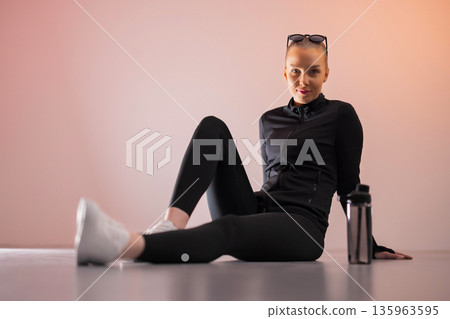 Active woman sitting on studio floor 135963595