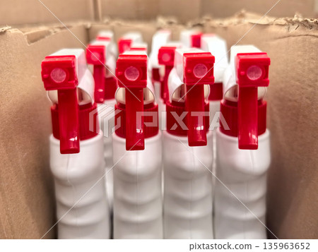 Bottles with red spray nozzles arranged neatly in a cardboard box Bottles with red spray nozzles arranged neatly in a cardboard box 135963652