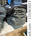 Neatly folded jeans display in a clothing store during daytime shopping hours 135963653