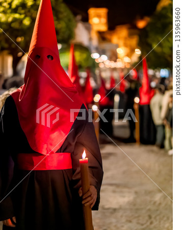 Nazareno holding a lit candle during holy week procession Nazareno holding a lit candle during holy week procession 135963660