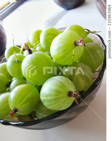 A vase with green gooseberries. A vase with green gooseberries. 135963964
