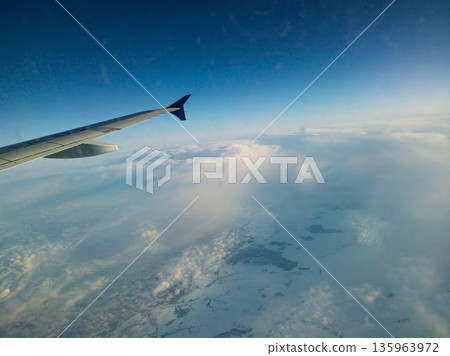 A plane is flying through the sky with a tail wing A plane is flying through the sky with a tail wing 135963972