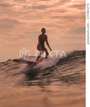 Sunset Enthusiast Concentrates On Powerful Surfing Techniques Sunset Enthusiast Concentrates On Powerful Surfing Techniques 135964279