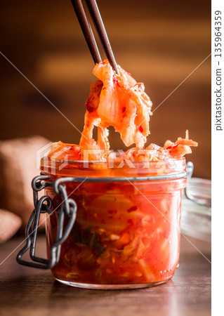 Fermented cabbage. Kimchi. Korean food in jar on wooden table. Fermented cabbage. Kimchi. Korean food in jar on wooden table. 135964359