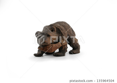 A souvenir from Hokkaido: A wooden carved bear eating a salmon A souvenir from Hokkaido: A wooden carved bear eating a salmon 135964504