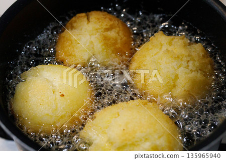 Sata andagi (a traditional Okinawan sweet) being fried Sata andagi (a traditional Okinawan sweet) being fried 135965940