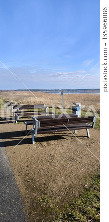 Wooden benches and tables for relaxing on the lake shore Wooden benches and tables for relaxing on the lake shore 135966086