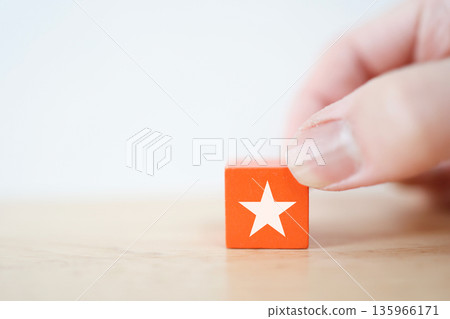 Orange block with star symbol. Image of rating and attention. Orange block with star symbol. Image of rating and attention. 135966171