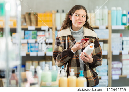 Young woman scanning qr code of cream 135966739