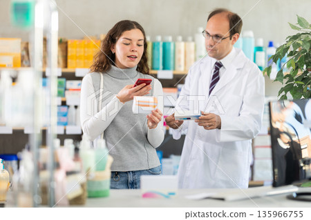 Woman buyer scans pills qr code with man pharmacist 135966755