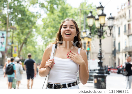 Cheerful young girl walking along summer La Rambla in Barcelona 135966821